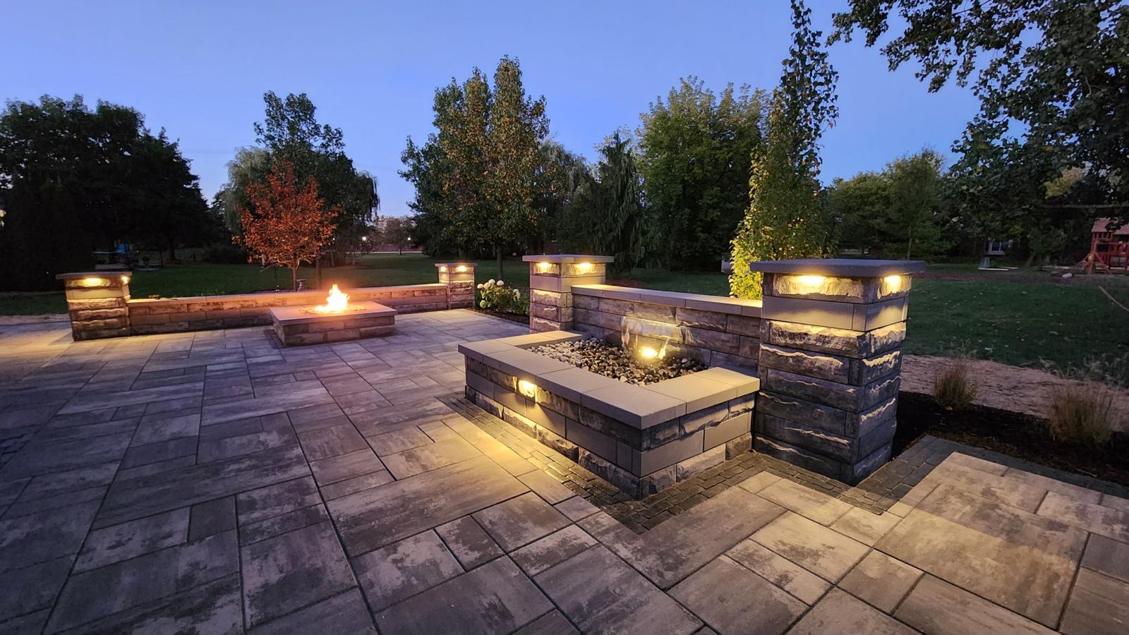 Illuminated stone patio with water feature